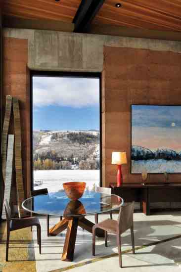 Katherine and Tom purposefully chose their new home's artwork. The mountain view painting by Theodore Waddell of Lyndsay McCandless Contemporary brings the outdoor landscape inside. The freestanding sculptures on either side of the window, made of recycled newsprint by Kate Hunt, gives a natural softness to the building's rigid forms.
